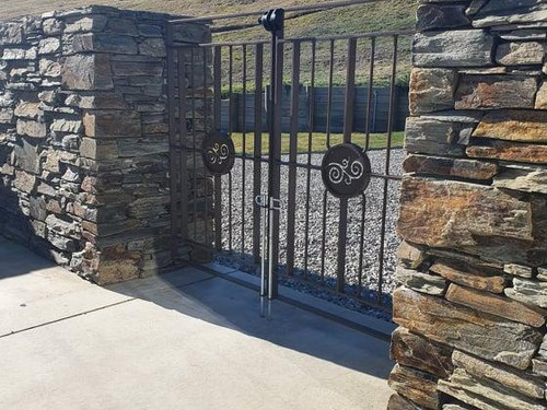 Iron and stone gateway with automatic gate by Otago Engineering