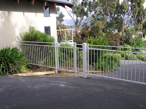 Modern white gate and fence with pedestrian gateway