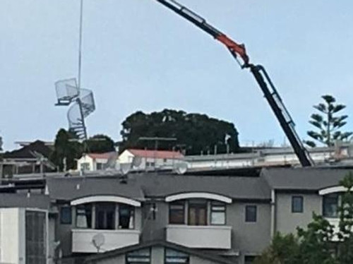 A crane lowering the Spiral Staircase into position, manufactured by Otago Engineering