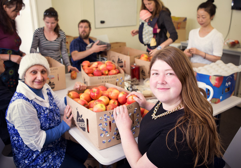 Valley Project manager Tess Trotter helps volunteers sort apples for an upcoming apple press day.