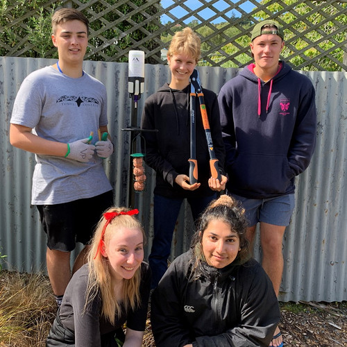 Students install a Pekapeka bird feeder at the rear of the community rooms