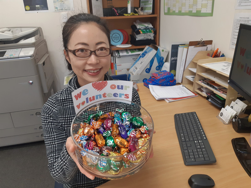 Volunteer receptionist Yoko Kurata with some sweet treats for National Volunteer Week