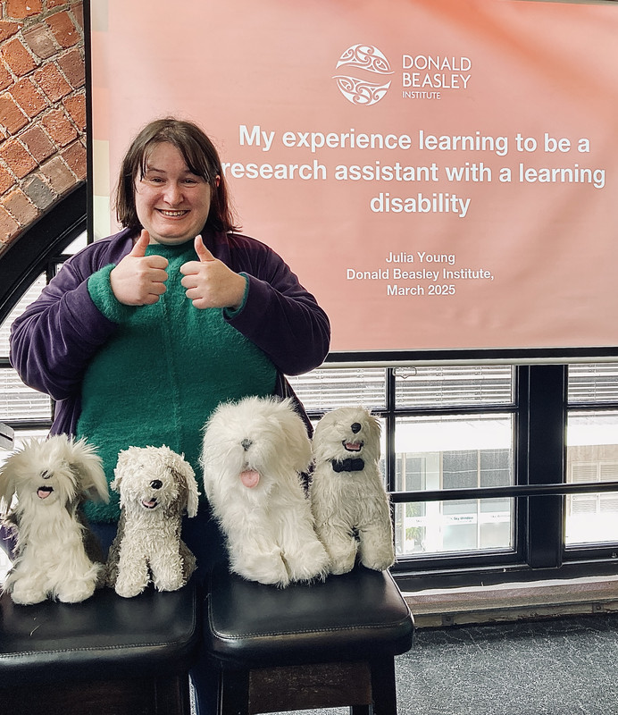 The photo shows Julia and Dog Migos at the NZASID conference. 