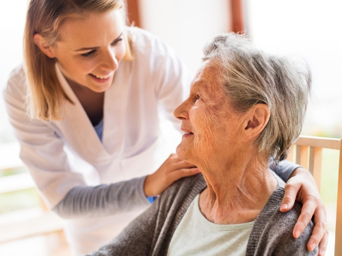 Elderly woman comforted by nurse