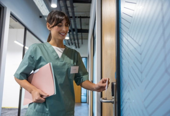 Nurse swiping card to open door.