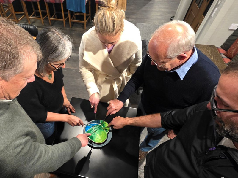 The five Aroha Cambridge Trustees cutting a celebratory cake