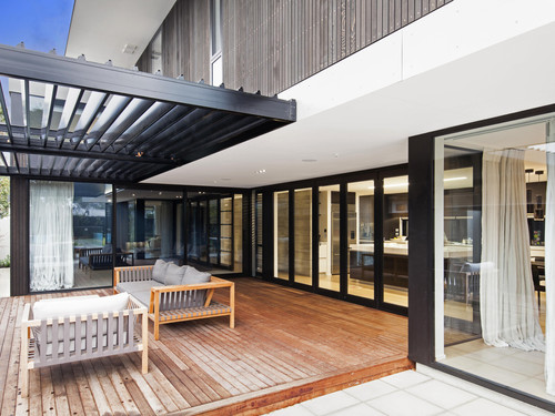 The exterior features floor to ceiling windows and doors