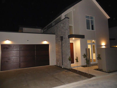 The front door and garage in cedar make a feature at night