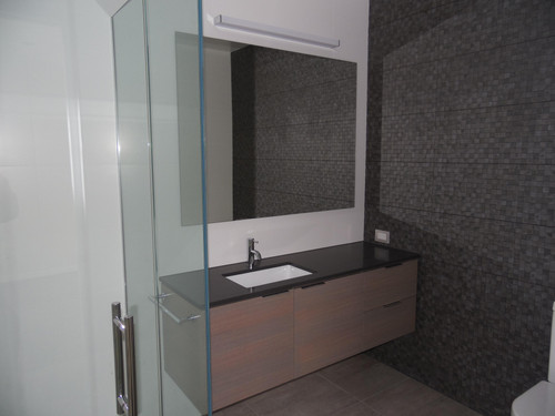 The bathroom vanity unit brings in that same woodwork with a feature tile