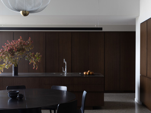 The kitchen with dark interior palette and foldaway cabinetry