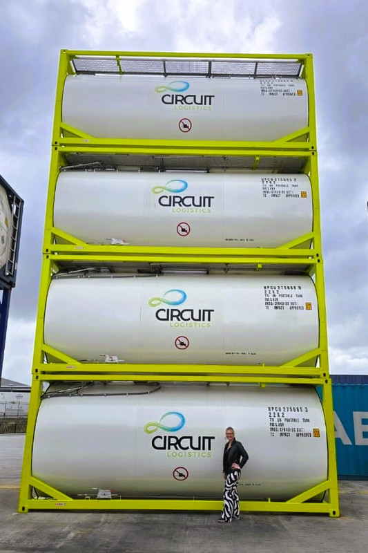 Four Tank Containers stacked on top of each other with Tanja standing in front of them.